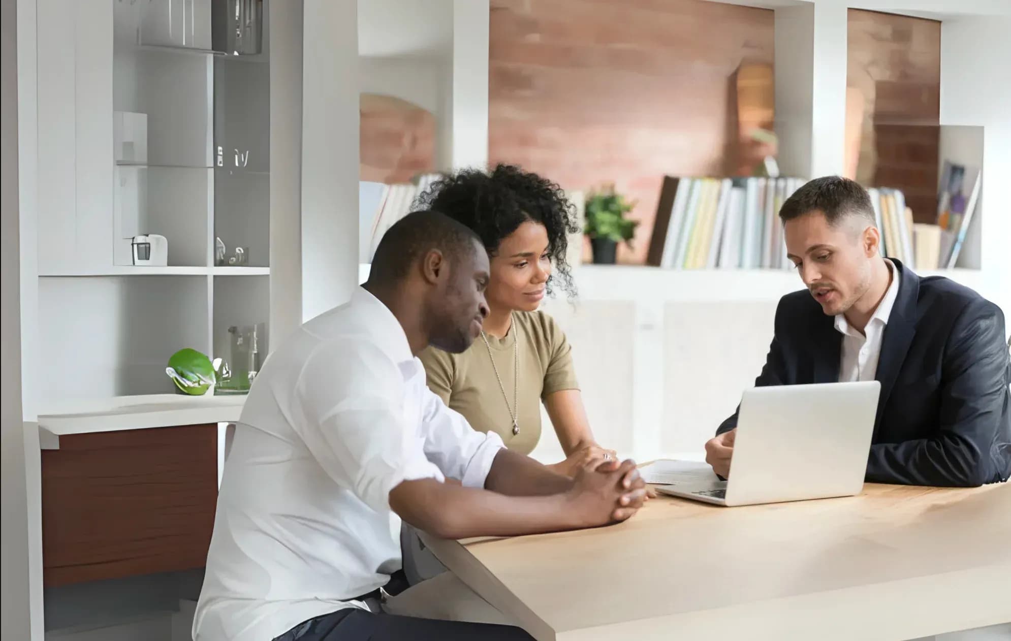 Un conseiller en assurance emprunteur accompagne un couple dans leur projet immobilier, illustrant l'opportunité de revenus complémentaires pour les professionnels de l'immobilier.