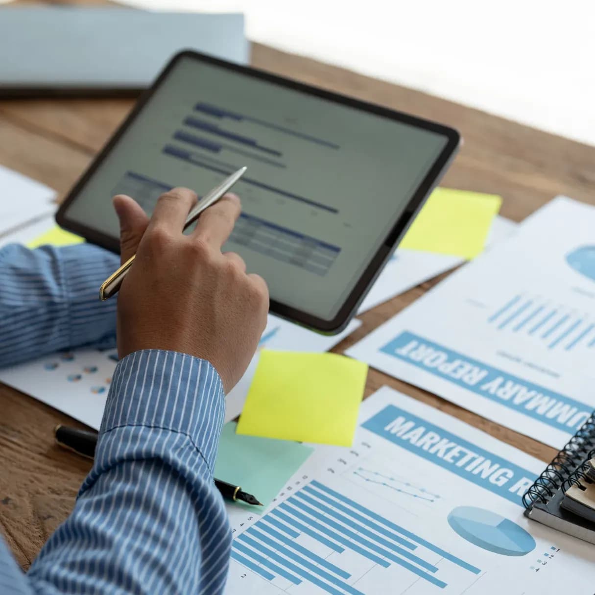 Expert financier calculant un budget prévisionnel immobilier avec une tablette et une calculatrice