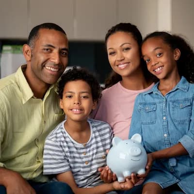Famille souriante économisant pour aider leurs enfants à devenir propriétaires avec une tirelire